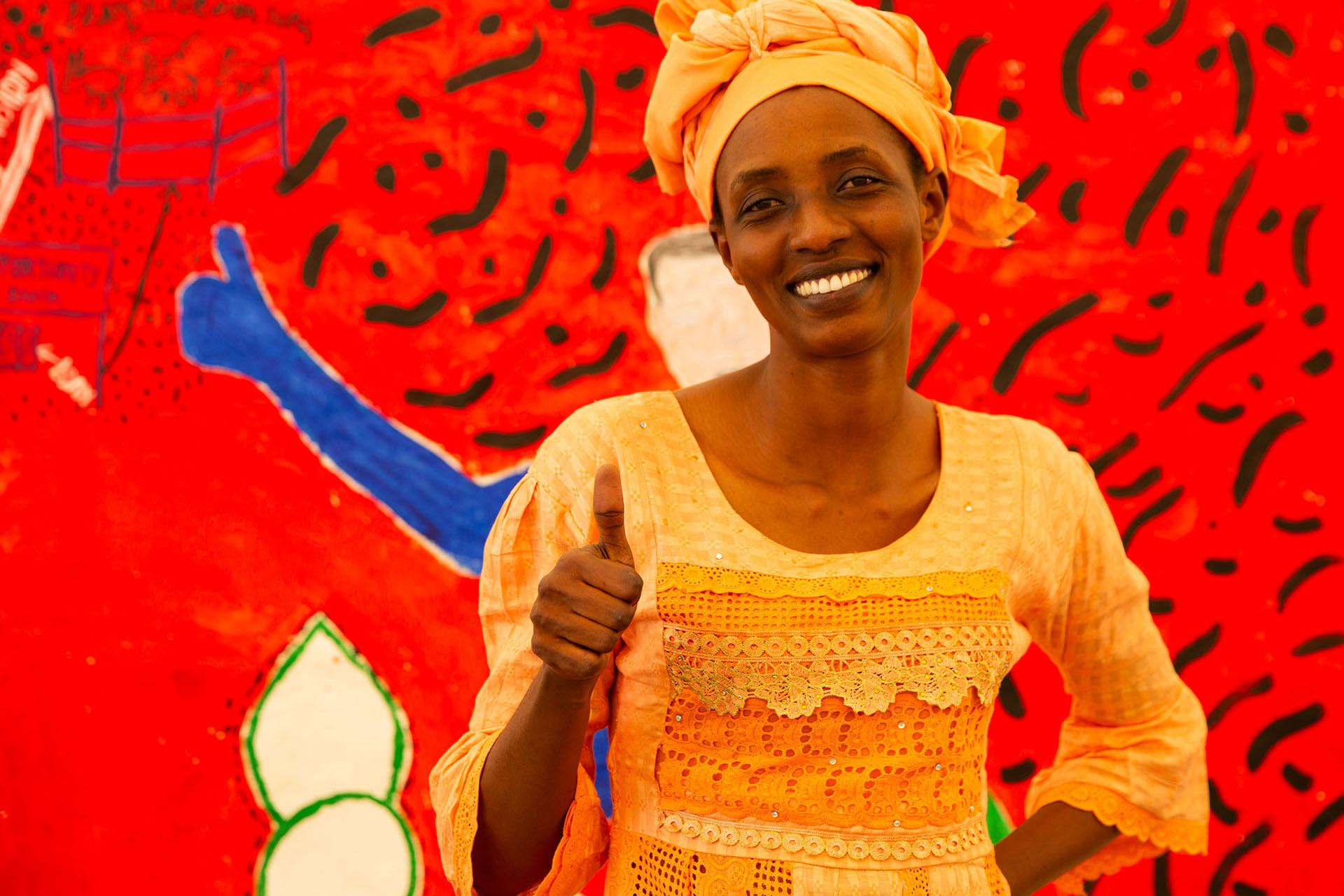 Women in front of red mural